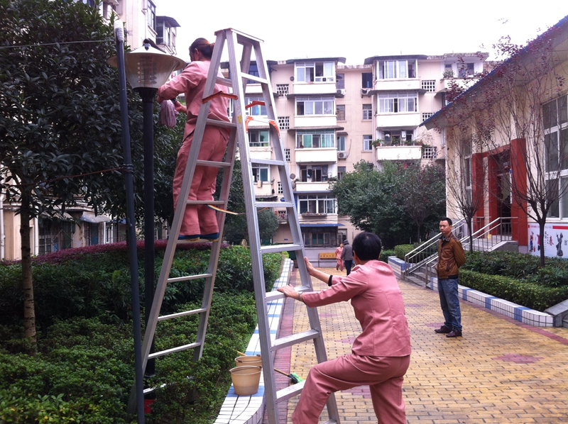 衛(wèi)生員對路燈進(jìn)行保潔